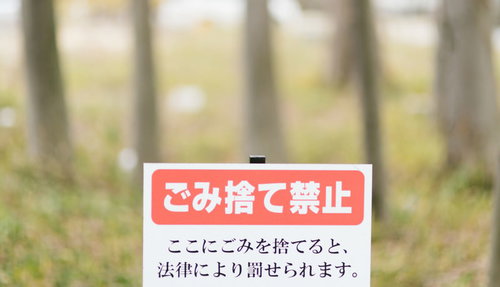 ごみ捨て禁止の赤い警告看板、法律違反の注意書き表記