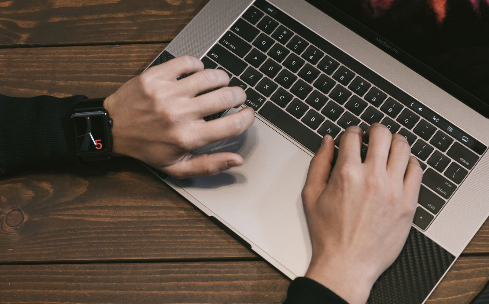 MacBook ProをタイピングするApple Watch着用の手