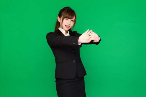 肩こりが酷くて両手を前に出して伸びをする事務のビジネスウーマン（グリーンバック）