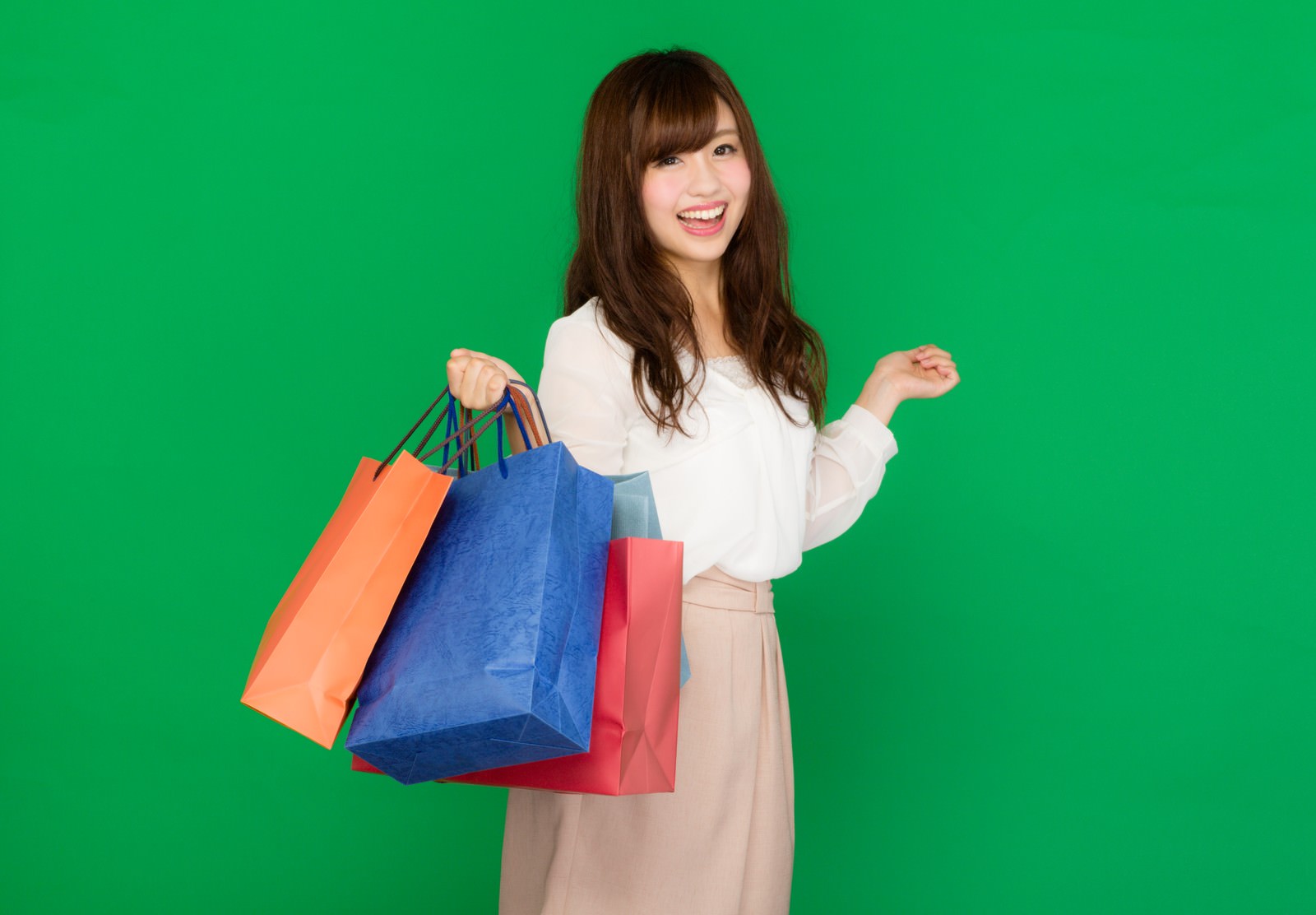 グリーンバックで買い物袋を持つ笑顔の女性［モデル：河村友歌］