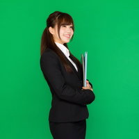 グリーンバックの前でリクスーを着た就活生の写真