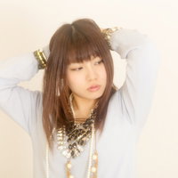 目を閉じて両手を頭の後ろに置くアクセサリーの女性の写真