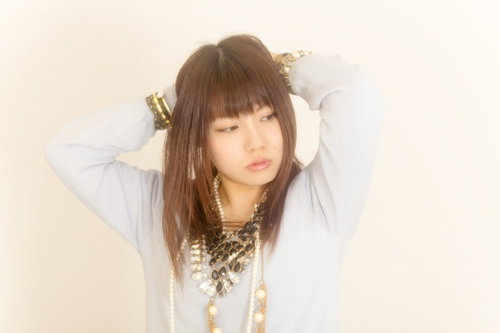 目を閉じて両手を頭の後ろに置くアクセサリーの女性