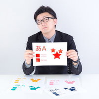 赤い文字の色見本を持つスーツの男性の写真