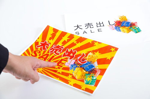 「大売出 SALE」のチラシを手に持つ