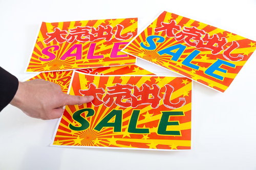 3枚の「大売出し SALE」ポスターを指差す手