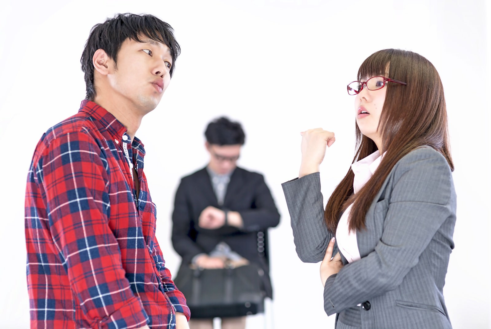 こぶしを握って男性に詰め寄る女性［モデル：大川竜弥 Lala OZPA］