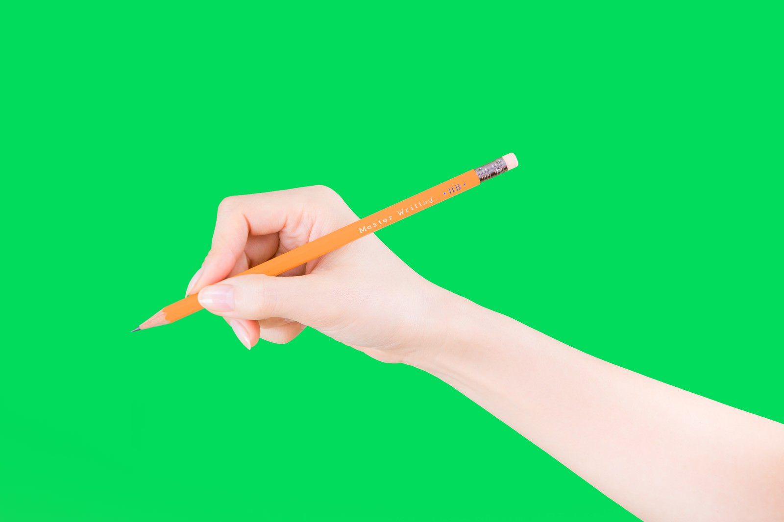 緑色背景で鉛筆を持って書く白い手［モデル：MOA］
