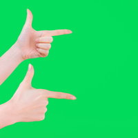 グリーンバックで両手を広げて指をさすゲッツポーズの写真