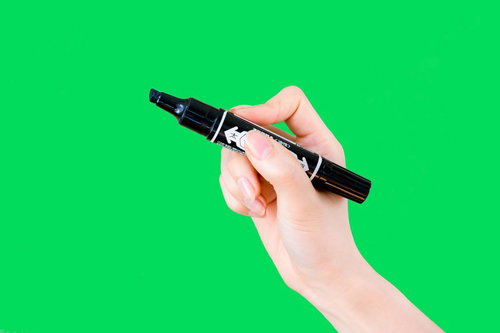 黒い油性ペンを持った手（グリーンバック）の写真