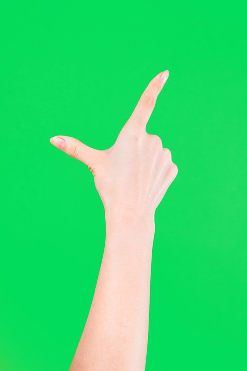 グリーンバック背景でのピンチアウト操作をする手の写真