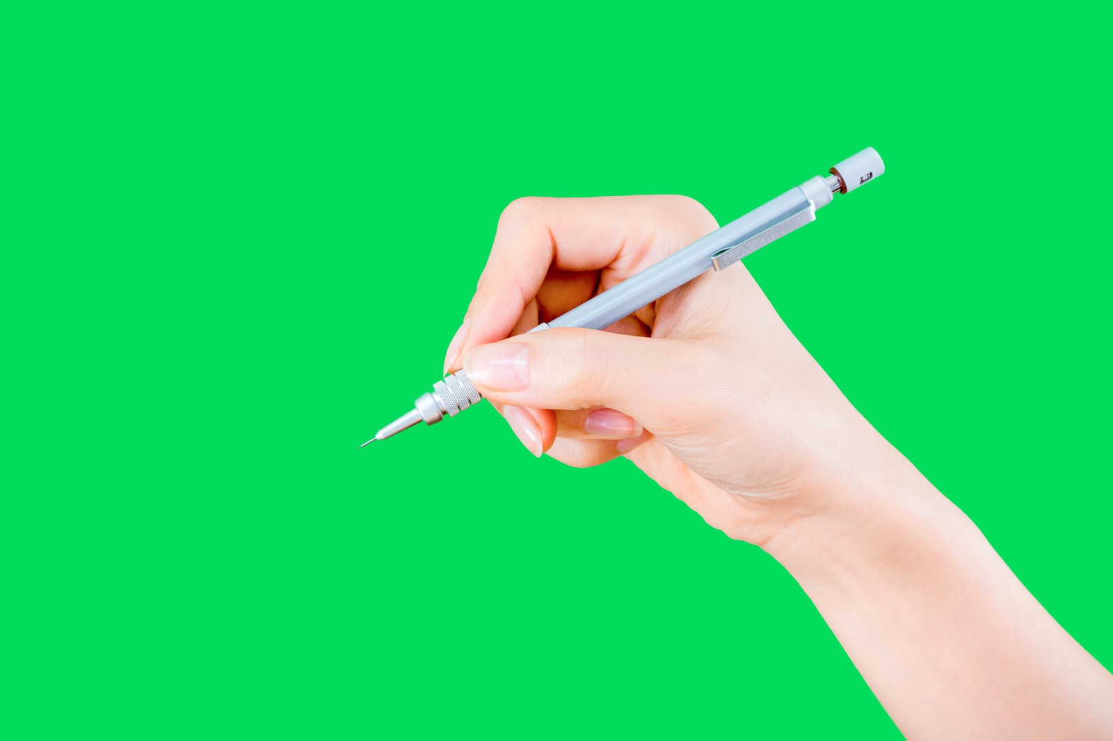 グリーンバック背景でシャーペンを握る手元のクローズアップ［モデル：MOA］