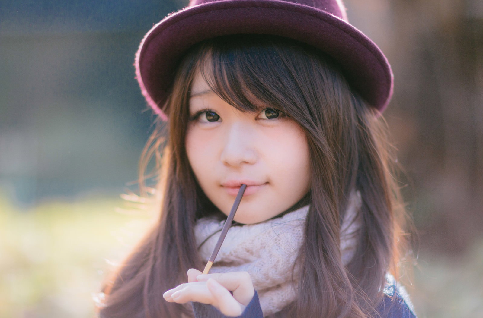 ピンク帽子姿の女性がポッキーを口にくわえた横顔アップショット［モデル：茜さや］