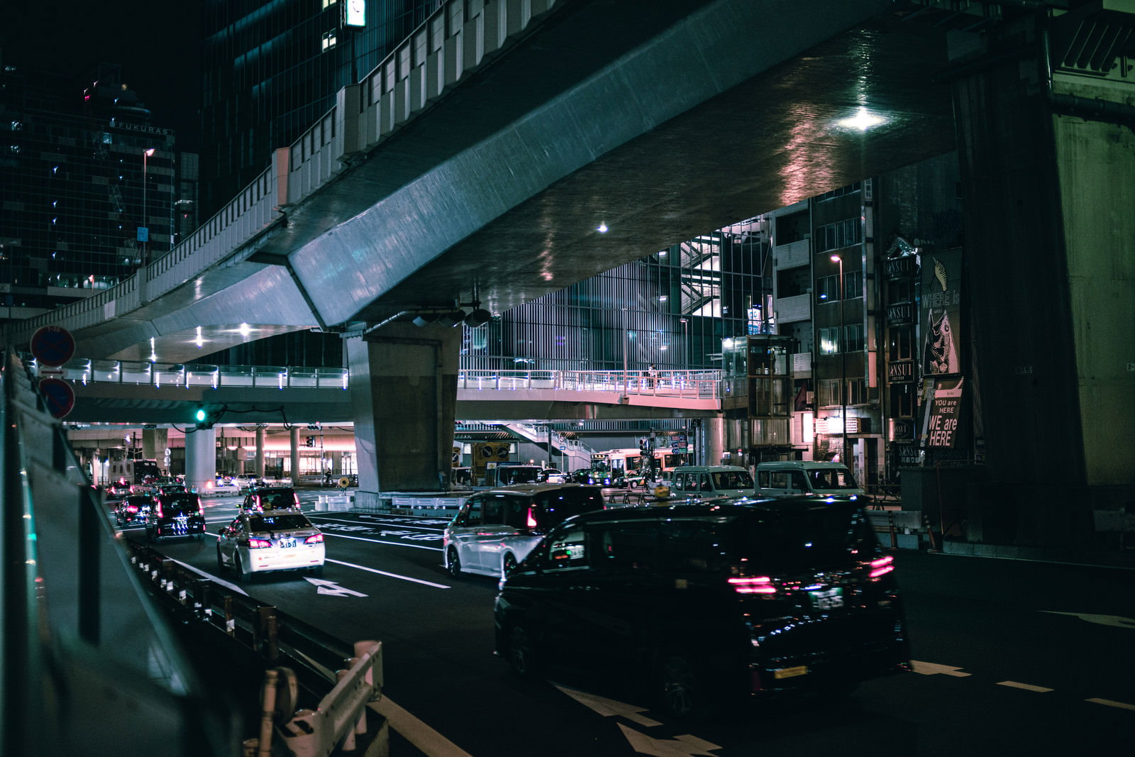 夜の渋谷東口歩道橋から見た車と電車が行き交う都市風景