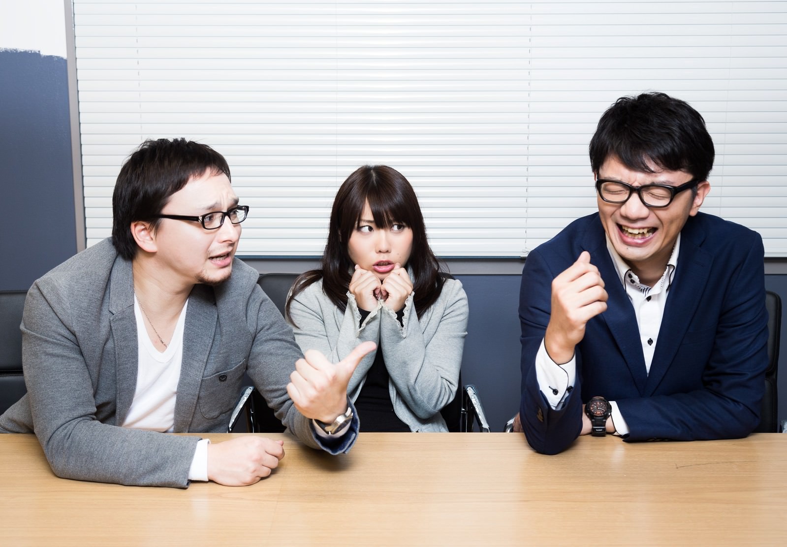 職場で驚く女性と笑う男性2人［モデル：OZPA Lala Max_Ezaki］