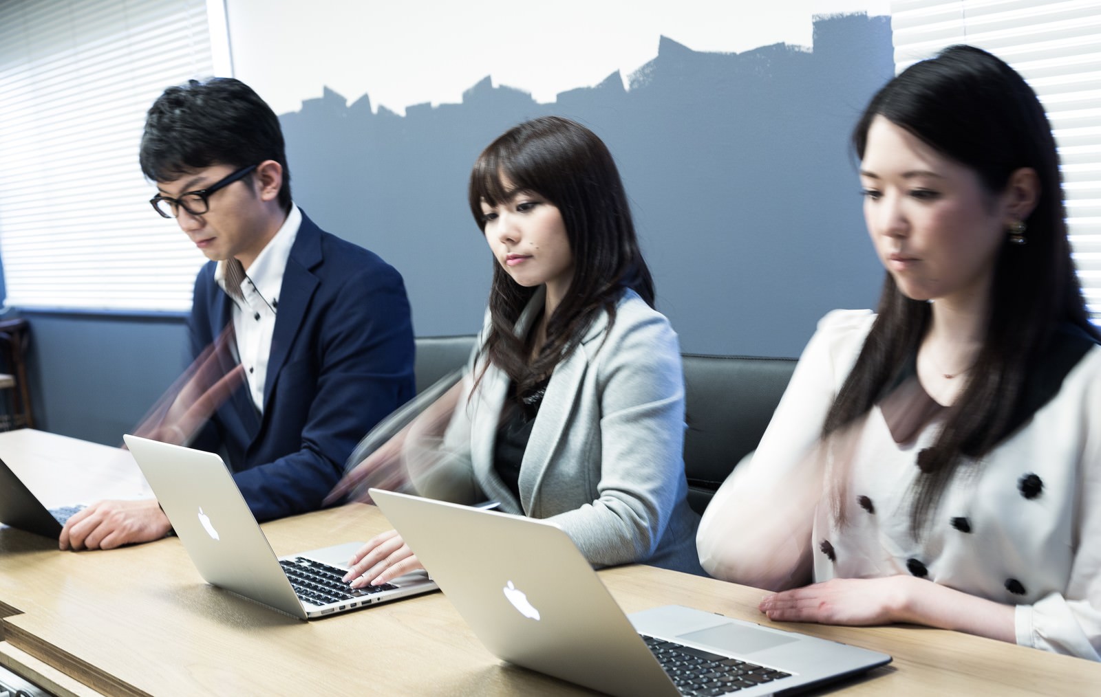 会議室でノートPCを操作する男女3名［モデル：OZPA Lala シマヅ］