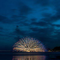 鎌倉花火大会で海上に咲く水中花火と夜景の写真