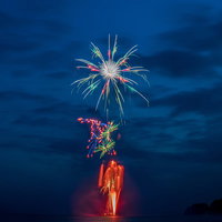 海上から打ち上がる花火大会の夜景の写真