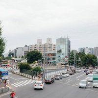 原宿駅前の交差点で往来する人と車、高層ビル群の都会景観の写真