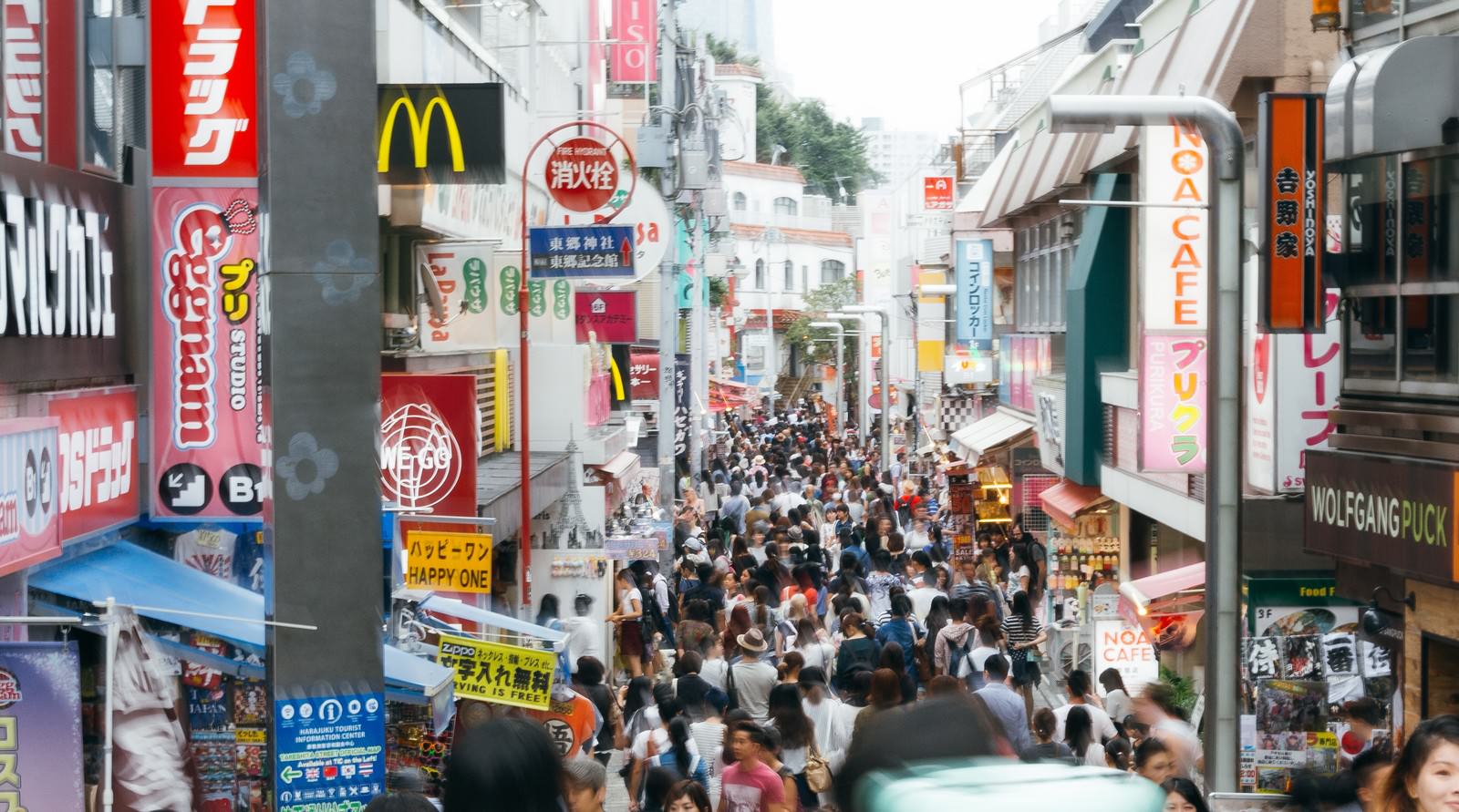 カラフルな看板が並ぶ原宿竹下通りで大勢の人々がショッピングを楽しむ様子