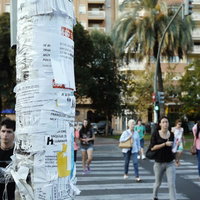 電柱にチラシが貼られたスペインの街角の写真