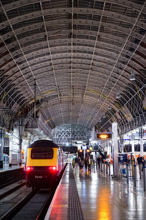 駅のホームから出発する赤い電車車両（海外）