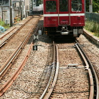 京浜急行川崎大師線の赤色車両が線路を走行する鉄道風景の写真