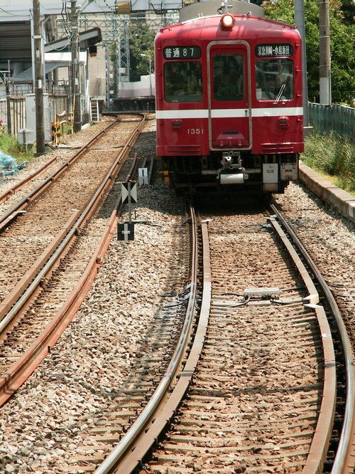 京浜急行川崎大師線の赤色車両が線路を走行する鉄道風景