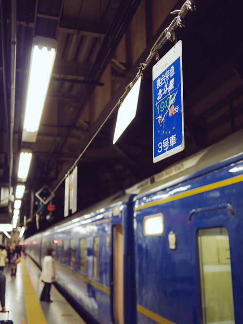 寝台特急北斗星の看板と駅のホーム、停車中の青い車両