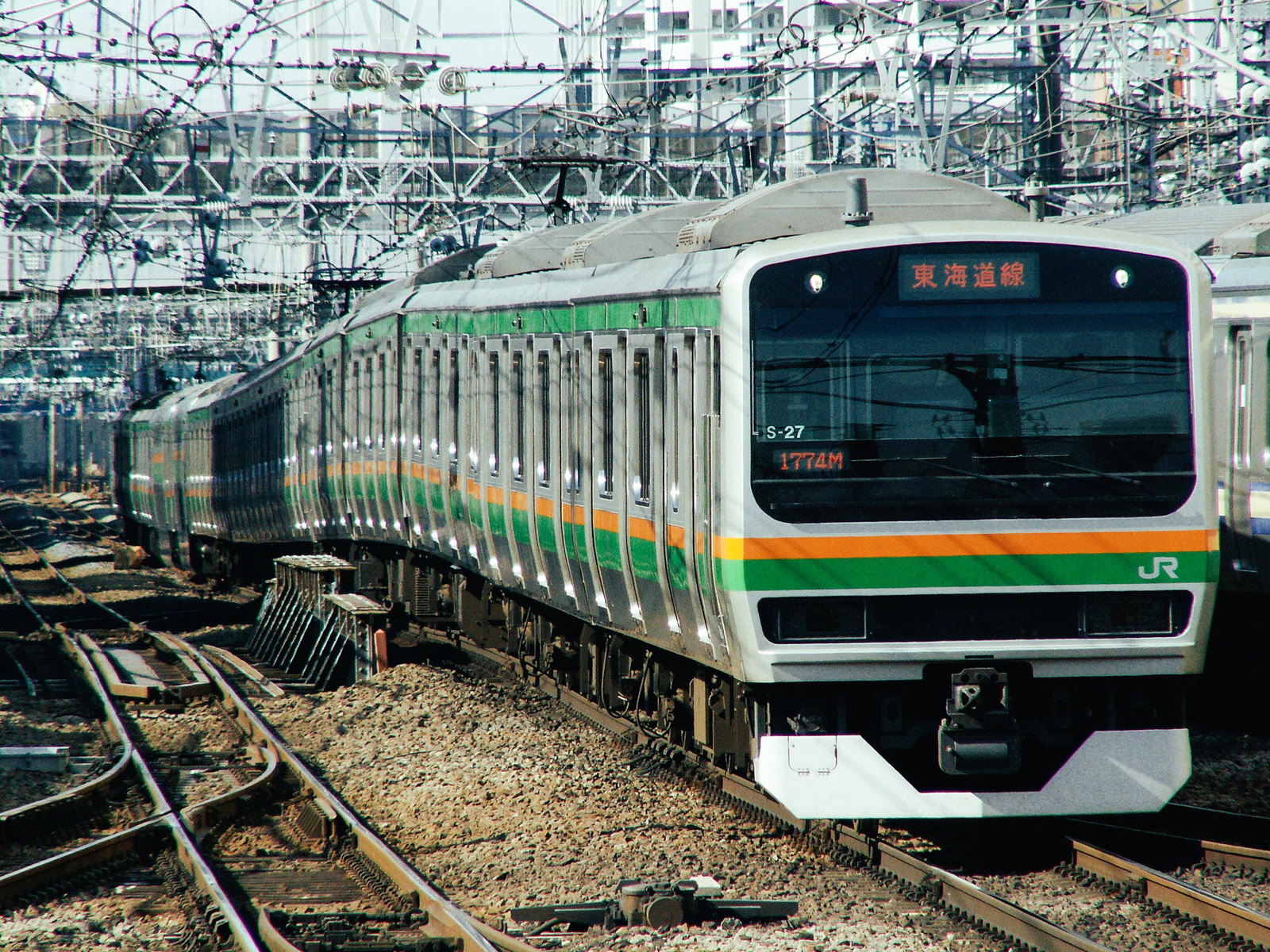 グリーンとオレンジのラインが入った東海道線E231系電車