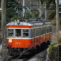 箱根登山鉄道のオレンジ色の電車が走行する線路風景の写真