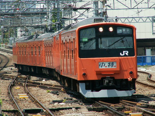 中央線201系の赤橙色電車が線路上に停車している風景