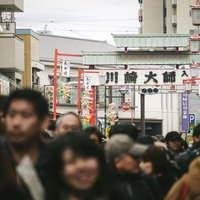 正月の参拝客で人混みに溢れる川崎大師の商店街の写真