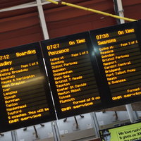 ロンドンの駅ホームに表示される列車の電光掲示板の写真