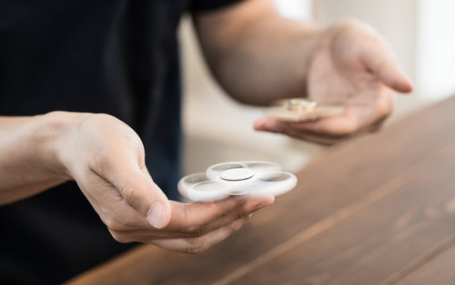 どちらのハンドスピナーが長時間回転し続けられるのか、両手で比較確認中