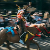 古殿八幡神社の境内を疾走する流鏑馬の騎手の写真