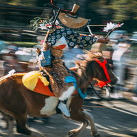 古殿八幡神社の境内で流鏑馬の騎手が駆け出す瞬間の写真