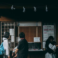 古殿八幡神社の境内にある授与所に立ち寄る参拝客の写真