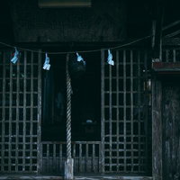 古殿八幡神社の境内に静かに佇む本坪鈴と鈴緒の写真