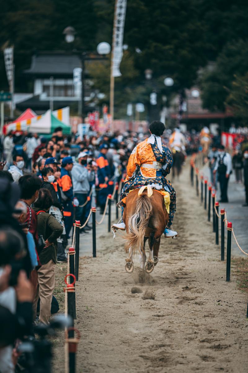 古殿八幡神社の境内で流鏑馬を行う騎手が馬を駆ける