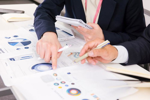 紙に印刷した資料とデータを使ってディスカッションする打合せ