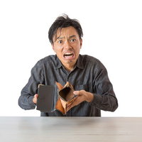 財布の中身が空っぽになって困った男性、金欠で悩むの写真
