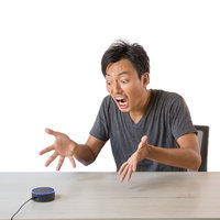 予想外の音声アシストに聞き返す男性のスマートスピーカーの写真