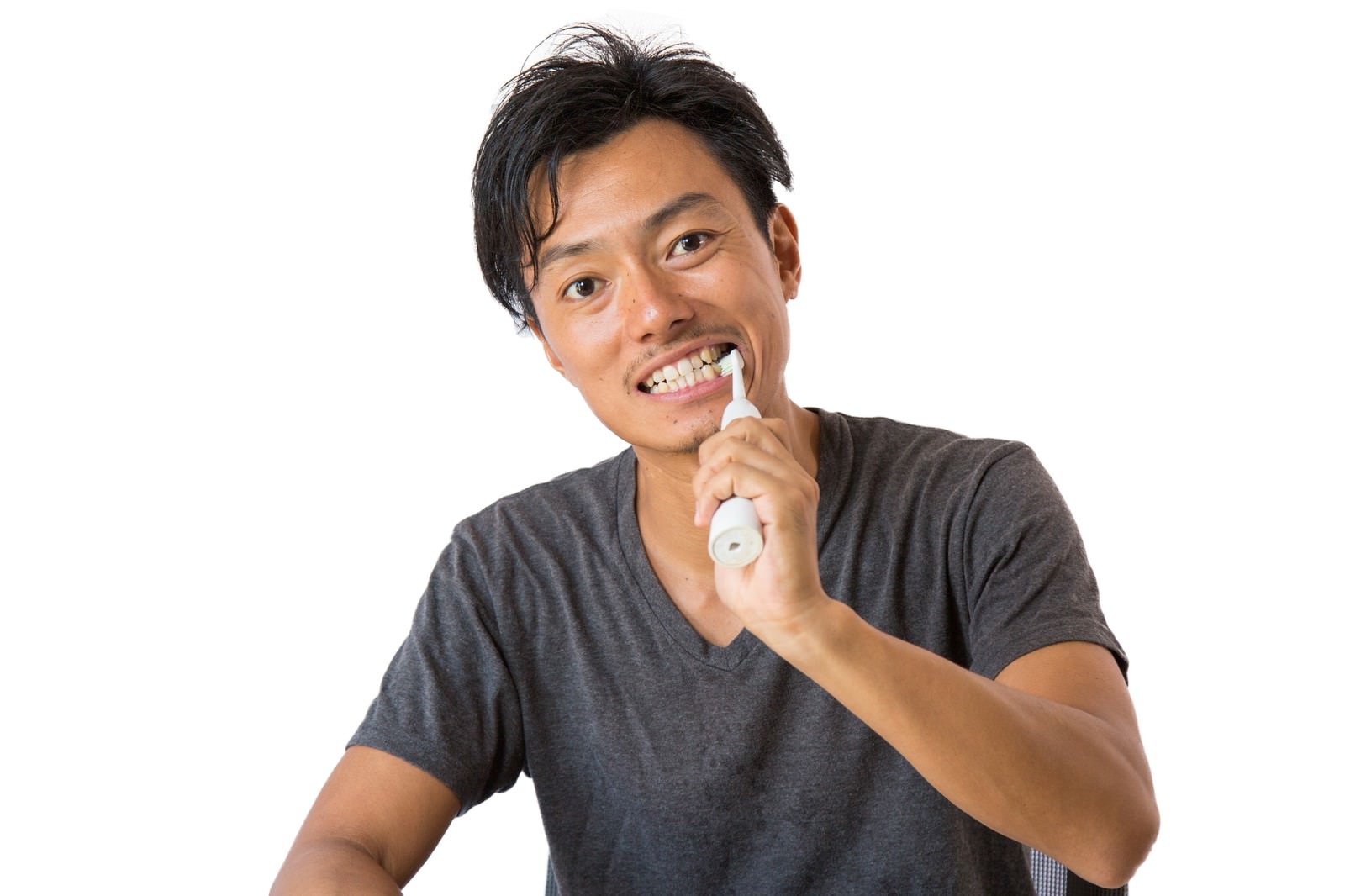 電動歯ブラシでデンタルケアを行う男性が考える表情を見せている［モデル：藤沢篤］