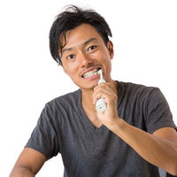電動歯ブラシでデンタルケアする男性の歯磨きの写真