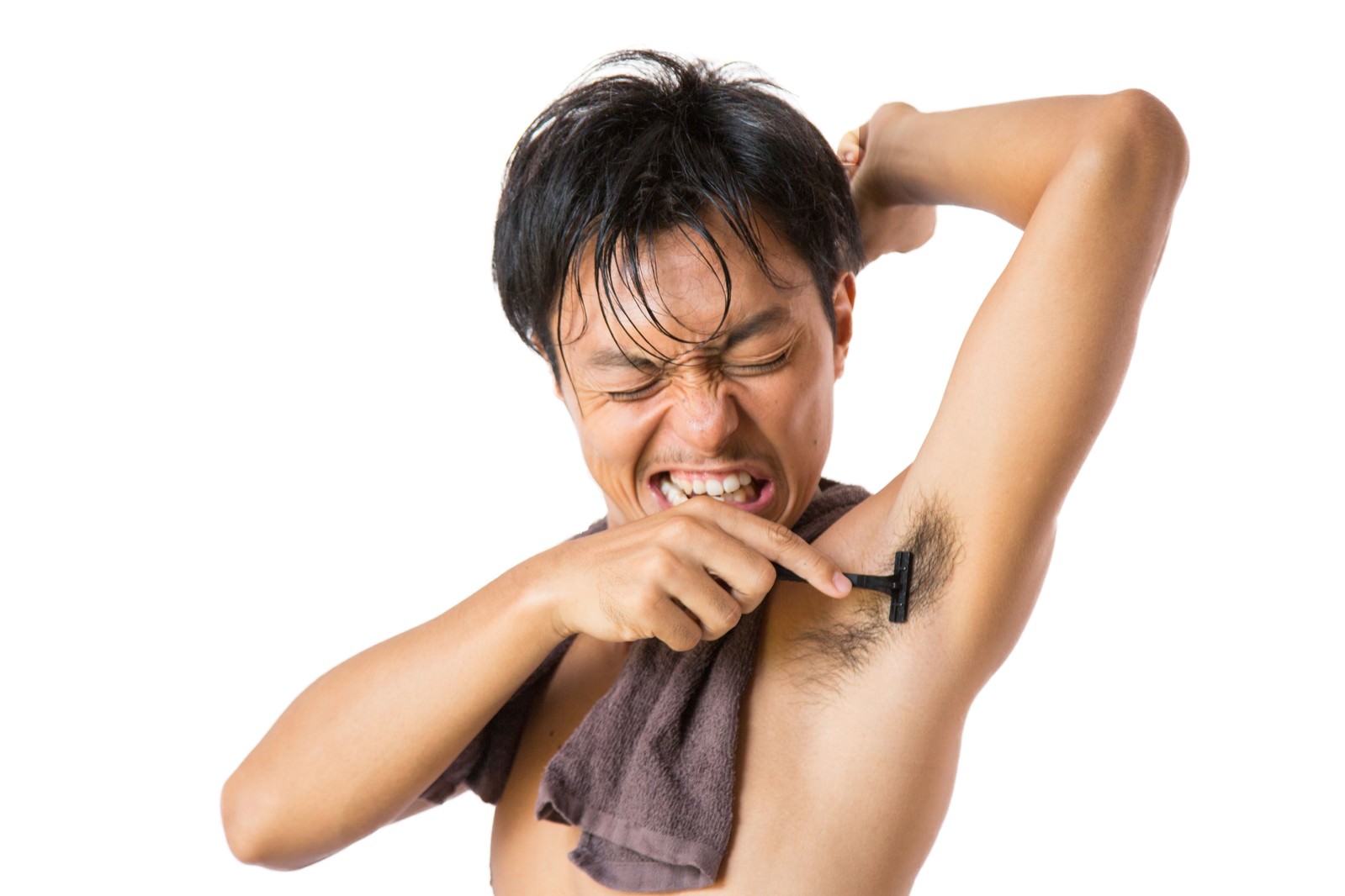 片手を頭の後ろに回してカミソリで脇毛を剃っている男性［モデル：藤沢篤］