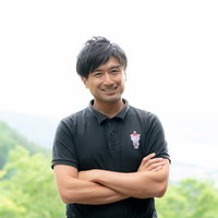 屋外で笑顔で挨拶する男性インストラクターの写真