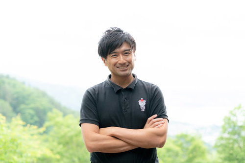 屋外で笑顔で挨拶する男性インストラクター