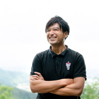 爽やかな笑顔で腕組みするゴルファー男性のポートレートの写真