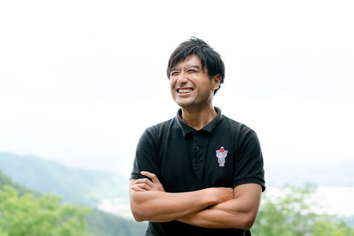 爽やかな笑顔で腕組みするゴルファー男性のポートレート